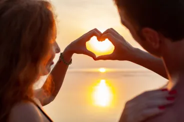 young-sexy-romantic-couple-in-love-happy-on-summer-beach-together-having-fun-wearing-swim-suits-showing-heart-sign-on-sundet-scaled.jpg