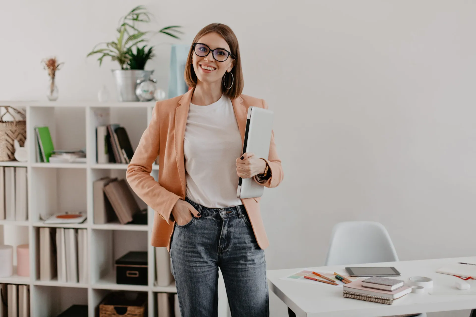 satisfied-female-entrepreneur-posing-with-laptop-hand-against-her-minimalistic-office-scaled.jpg